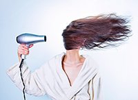 Femme séchant ses cheveux bouclés